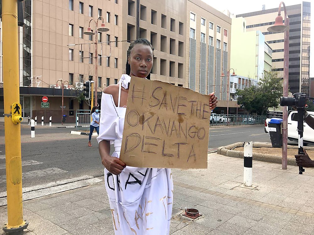 Woman with sign "Save the Okavango Delta"