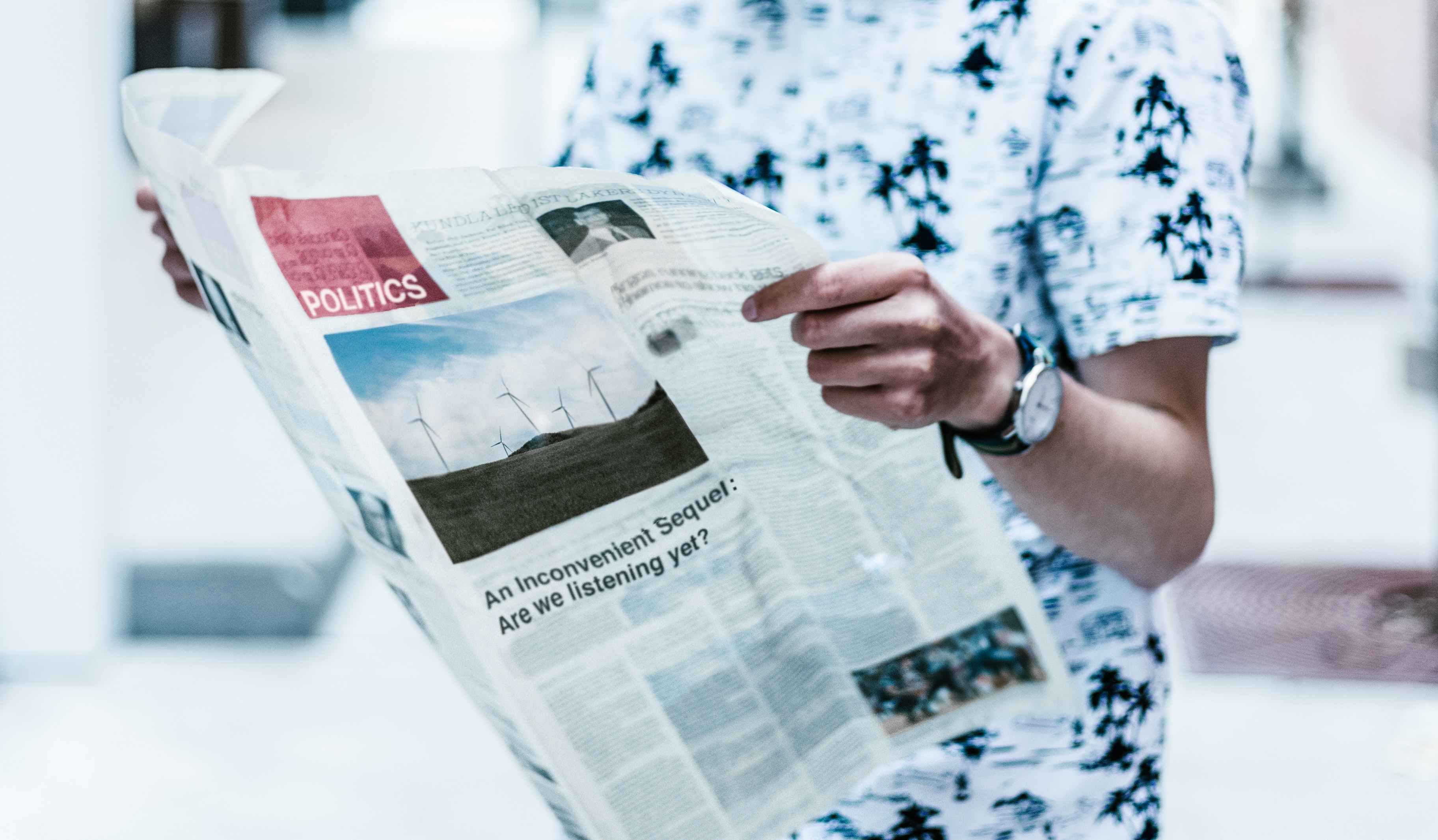 Standing man reading a newspaper.