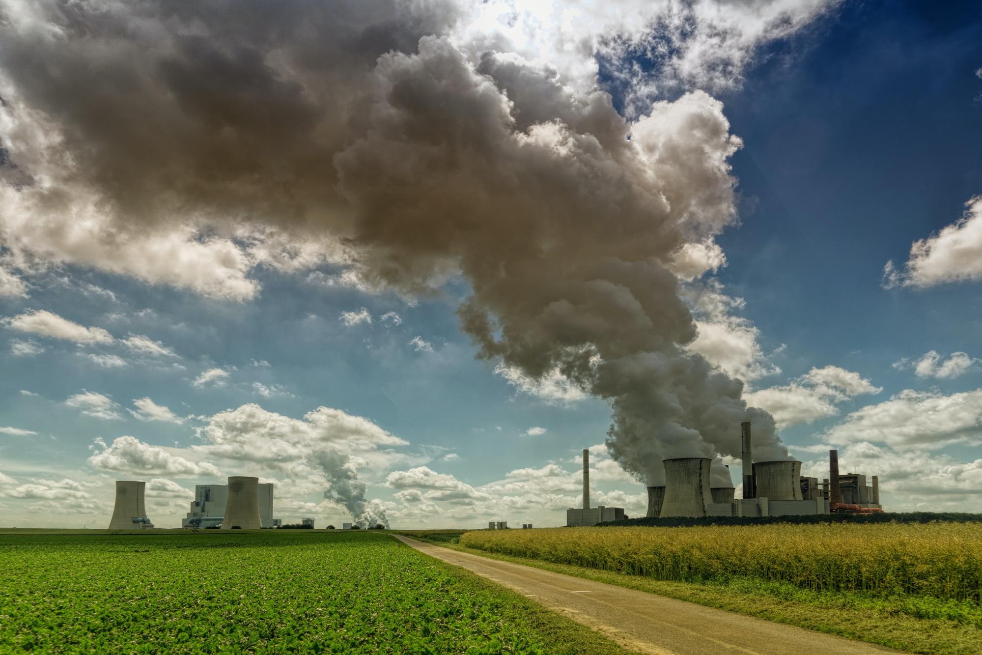 Smoke rising from a factory in a green field