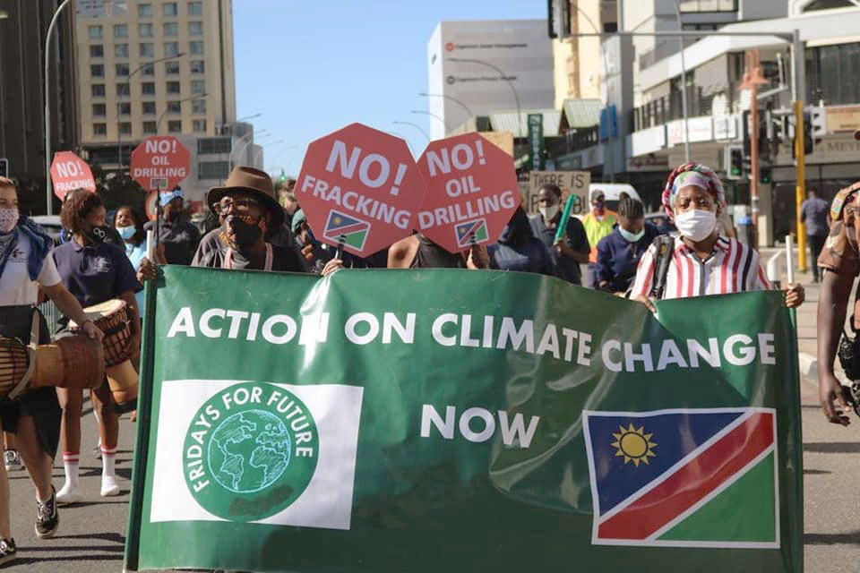 People with signs saying "No fracking!" and "Action on climate change now"